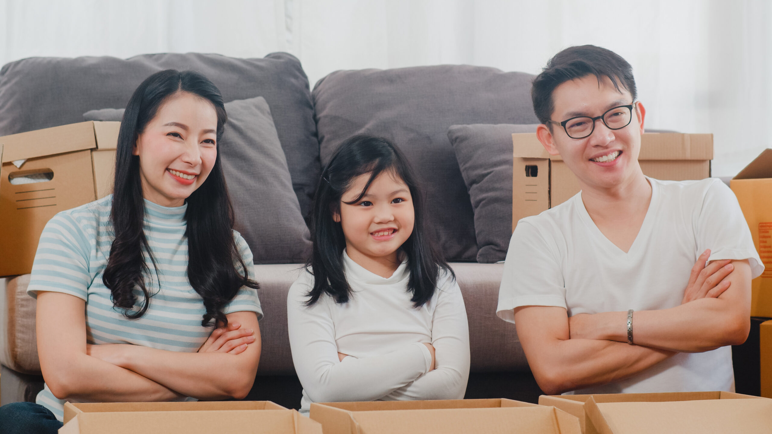 happy asian young family relocation removals settle new home chinese parents kids open cardboard box parcel unpacking living room moving day real estate dwelling loan mortgage scaled
